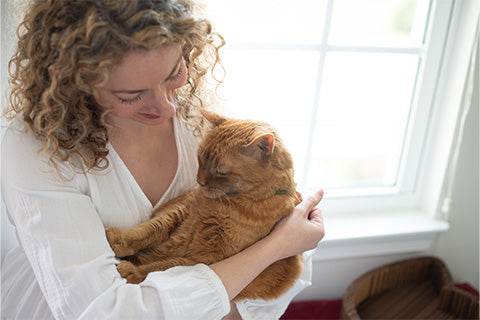 Woman holding her new cat at home