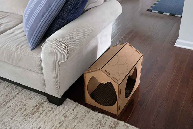 Cat scratcher house next to a couch